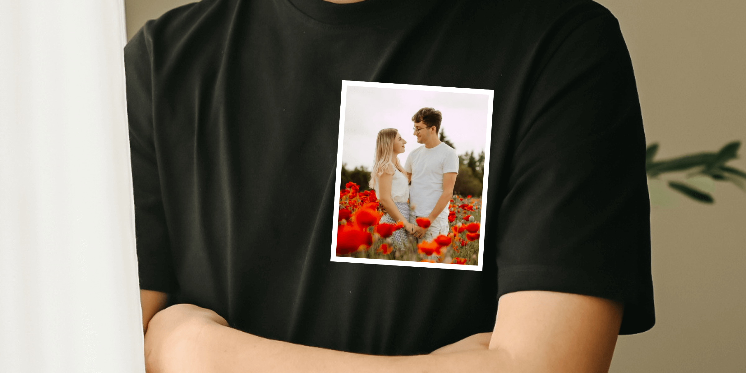 Detailní záběr na černé triko s fotografií objímajícího se páru na hrudi